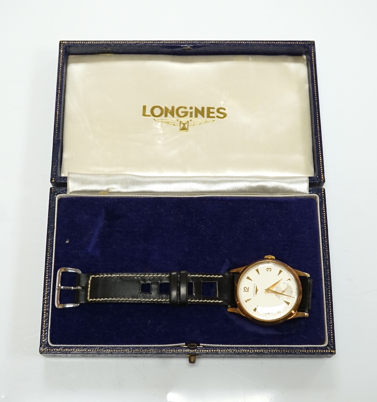 A gentleman's 9ct gold Longines manual wind wrist watch, with subsidiary seconds, case diameter 34mm, on a later associated leather strap, with Longines box. Condition - fair